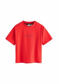 Camiseta de algodón roja con cuello redondo, mangas cortas y la palabra "BAKER" impresa en azul oscuro en el pecho.