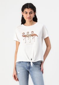 Hvid bomulds t-shirt med rund halsudskæring, korte ærmer og en knude-detalje foran. Har pailletterede flamingoer i guld, rosaguld og sølv.