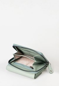 Portafoglio in pelle verde con chiusura a zip. Presenta più scomparti e un interno a linee geometriche. Design compatto e strutturato.