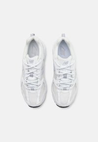 Baskets de course blanches en mesh avec un dessus texturé, dotées de lacets, d'une semelle intérieure rembourrée et d'une semelle extérieure noire. Logo de la marque visible sur les côtés.