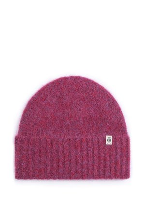 Soft, fuzzy purple knit beanie with ribbed fold-over cuff and small rectangular logo tag on cuff against plain white background.