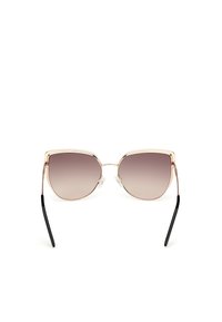 Gafas de sol estilo cat-eye con lentes degradados, montura de metal dorado y patillas negras. Presentan almohadillas nasales transparentes para mayor comodidad.