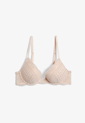 Reggiseno beige chiaro con pizzo, dotato di coppe preformate, spalline regolabili e dettagli floreali intricati, con bordi scallop e una texture morbida.