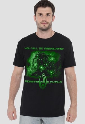 Schwarzes Baumwoll-T-Shirt mit einem grünen Grafikdesign eines Würfels und dem Text "DU WIRST ASSIMILIERT WERDEN" und "WIDERSTAND IST SINNLOS."