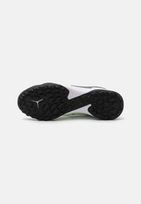 Suela de goma negra con patrones de agarre texturizados, mediopie blanco con acentos en verde brillante, con un diseño de soporte de arco.