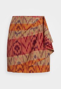 Hame ikat-kuvioilla, joissa on kirkkaat punaiset, oranssit ja beige värit. Ominaisuuksiin kuuluu roikkuva muotoilu ja pehmeä, teksturoitu kangas.