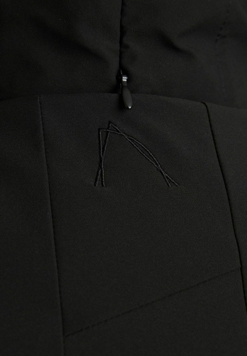 Czarna tkanina kurtki o gładkiej fakturze, z subtelnym, haftowanym geometricalnym detalem oraz zamkiem błyskawicznym u góry.