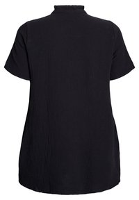 Black blouse with short sleeves, textured fabric, and a ruffled collar. Loose fit with a curved hem, no visible hardware or accents.