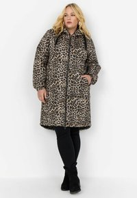 Manteau matelassé imprimé léopard avec capuche, fermeture éclair à l'avant, poches latérales et poignets élastiques. Tissu doux avec une texture chaude et rembourrée.