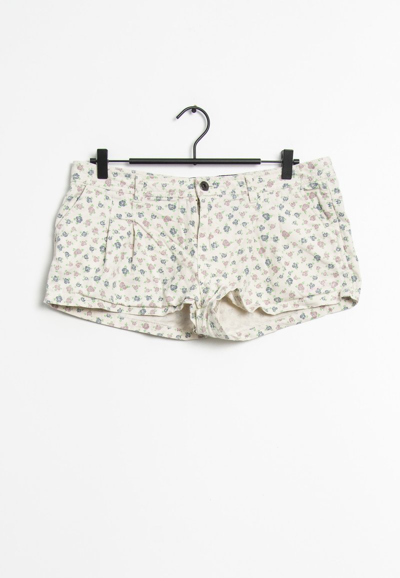 Shorts floreali con uno sfondo crema, decorati con piccoli fiori blu e rosa, dotati di chiusura frontale a bottone e due tasche laterali.