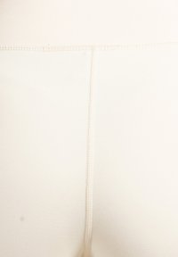 Beige leggings van getextureerde stof met een hoge taille en een naad in het midden aan de achterkant voor een aansluitende pasvorm. Overal gladde stikseldetails.