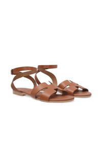 Bruine leren sandalen met een platte zool, met open zijkanten, een band met een enkelgesp en uitsparingen aan de voorkant.
