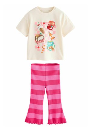 Korte mouw roomkleurig T-shirt met kleurrijke voedselthema grafiek; gecombineerd met roze en lichtroze gestreepte uitlopende broek met een gerimpelde zoom.