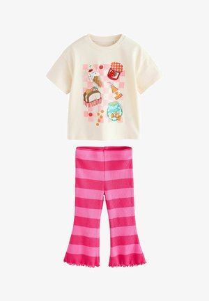 T-shirt crème à manches courtes avec un motif coloré sur le thème de la nourriture ; associé à un pantalon évasé rayé rose et rose clair avec un ourlet froncé.