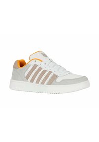 Sneaker blanche avec des accents gris et beige, présentant une finition en cuir lisse et en daim, six œillets et une doublure intérieure orange.