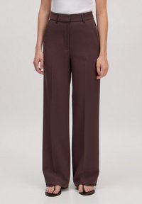 Wijde benen broek in een diep bordeauxrood. Gemaakt van een gladde stof met een tailor fit, met een hoge taille en zijzakken.