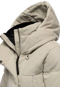 Giacca imbottita beige con cappuccio e superficie testurizzata, con interno nero, zip frontale e bottoni a pressione.