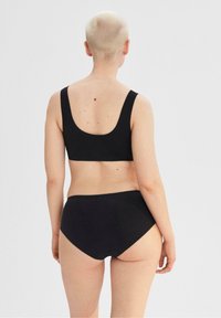 Musta bikinit-setti, jossa on avonainen kaula-aukko ja korkea vyötärö, valmistettu sileästä kankaasta, jossa on minimaaliset saumat eikä ylimääräisiä kuvioita.