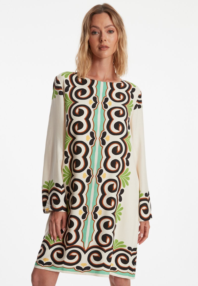 Langdurige jurk van lichtgewicht stof met een gedurfde abstracte print in zwart, groen en turquoise op een crèmekleurige achtergrond.