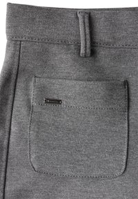 Grijze stoffen broek met een achterzak met een zwart metalen logo-tag, een elastische tailleband en gestikte details langs de randen.