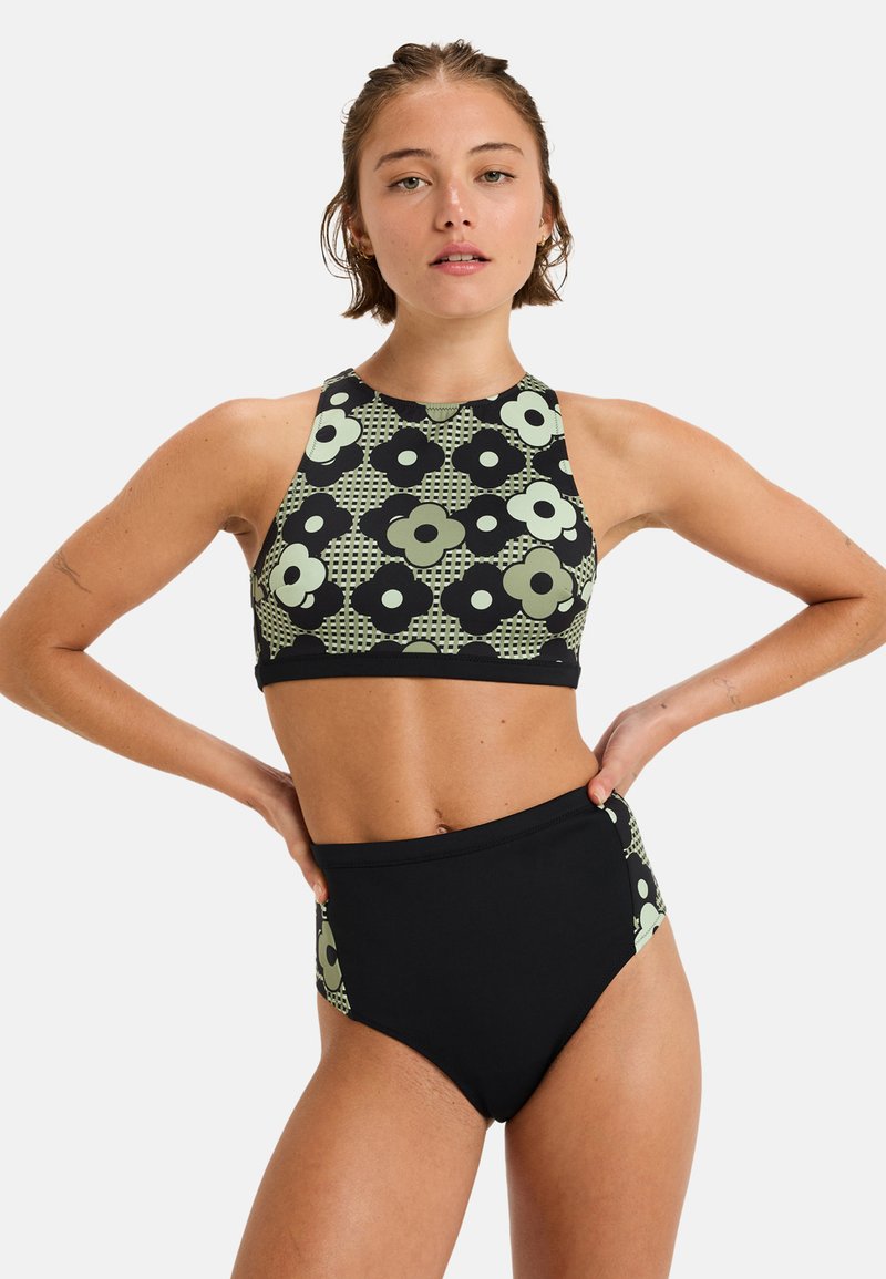 Čierne bikinové spodky s vysokým pásom v kombinácii s topom na halter s vzorom, ktorý má veľké zelené a čierne kvety a geometrické akcenty.