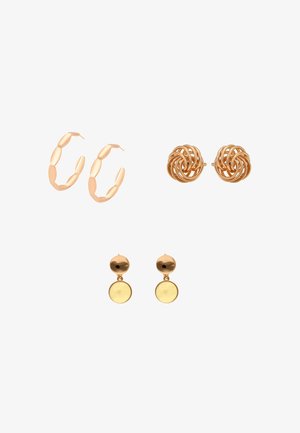 Három pár aranyszínű fülbevaló: ovális láncolt karika, csavart csomó pötty, valamint kerek lemezes csepp formák fehér háttéren.