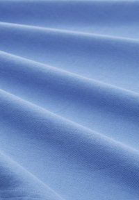 Světle modrá tkanina s hladkou strukturou, vykazující jemné záhyby a konzistentní vzor tkaní, vhodná pro různé textilní aplikace.