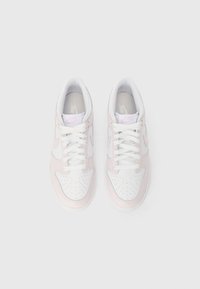 Balts un gaiši rozā Nike ikdienas apavi ar auklām, skatīts no augšas uz balta fona.