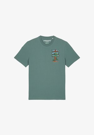 T-shirt en coton vert avec un col rond, ornée d'un graphique coloré de panneaux directionnels représentant des scènes de nature sur la poitrine gauche.
