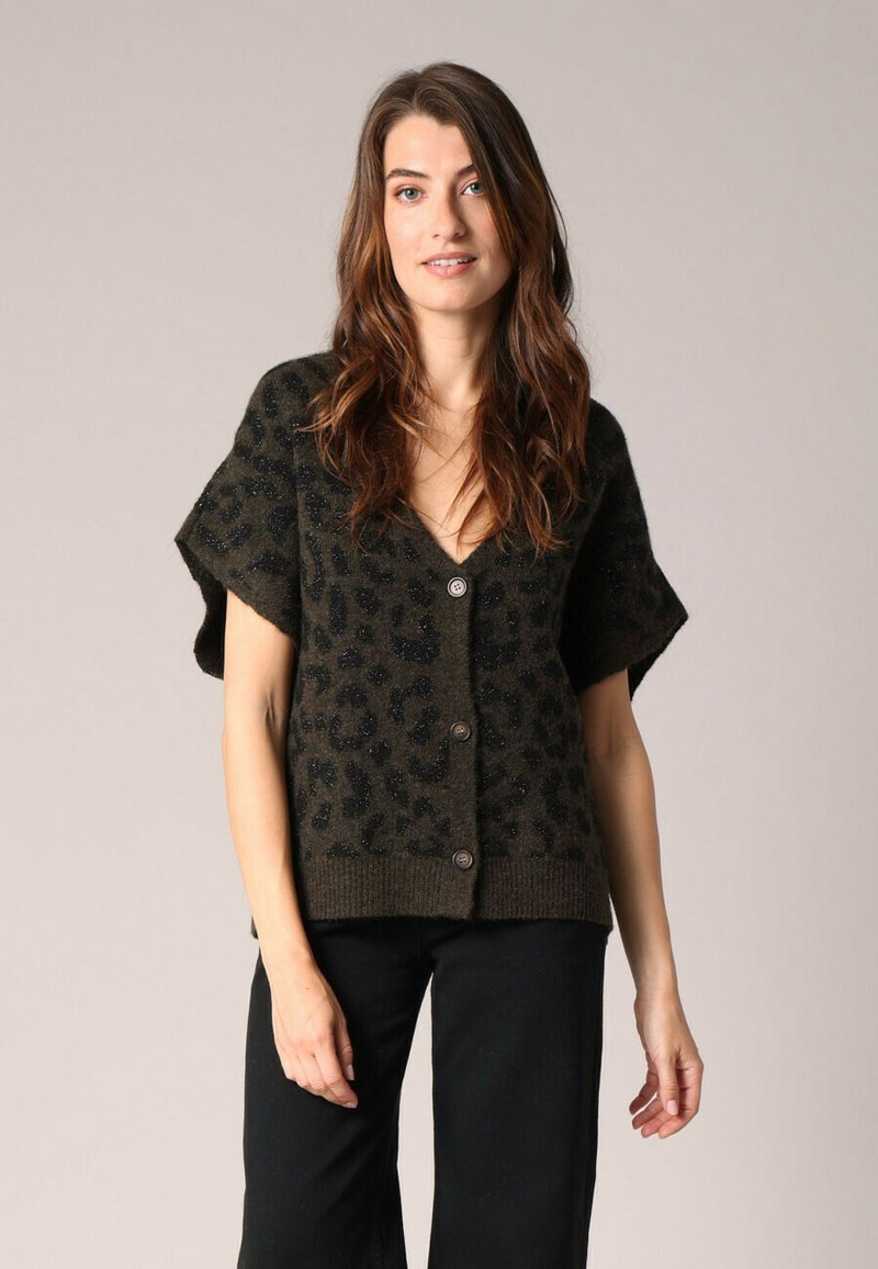 Cardigan à manches courtes, vert foncé avec un motif léopard. Fabriqué en matériau texturé, il présente des boutons sur le devant et un ourlet côtelé.