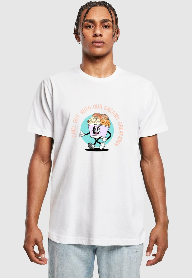 Hvid bomuld t-shirt med et tegneserie-isvaffel med et smilende ansigt, omgivet af teksten "CHILL OUT MED VORES CREMEDE KREATIONER."