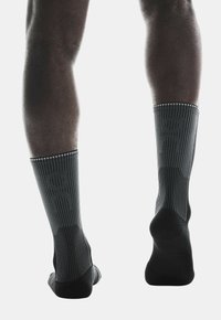 Černé sportovní ponožky s vertikálním žebrováním a logem. Design do kotníku, s hladkým povrchem a zesílenými špičkami a patami.