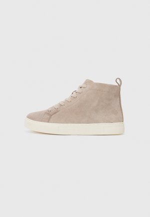 Sneaker haut en daim beige avec un bout rond, semelle en caoutchouc crème et laçage à l'avant. Dispose d'une languette au talon.