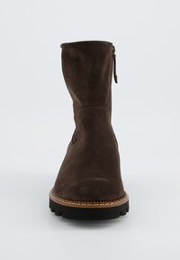 Bruine suède enkellaarzen met een ronde neus, zijrits en een gestructureerde zool. Beschikt over een gestikte afwerking langs de rand van de zool.