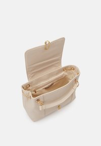 Beige Handtasche aus weichem Leder, ausgestattet mit einer Reißverschlusstasche im Inneren, goldfarbenen Metallakzenten und einem Kettenriemen, der an den Seiten befestigt ist.