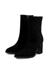Un par de botas de tobillo de ante negro con punteras puntiagudas, cremalleras laterales y tacones cuadrados sobre un fondo blanco.
