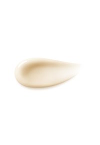 Crema beige chiaro con una consistenza liscia e lucida, a forma di goccia, spalmata leggermente su una superficie bianca.