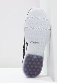 Suola della scarpa Nike Zoom nera con uno strato bianco traslucido, caratterizzata da un pattern esagonale e un branding distintivo. Testurizzata per una migliore aderenza.
