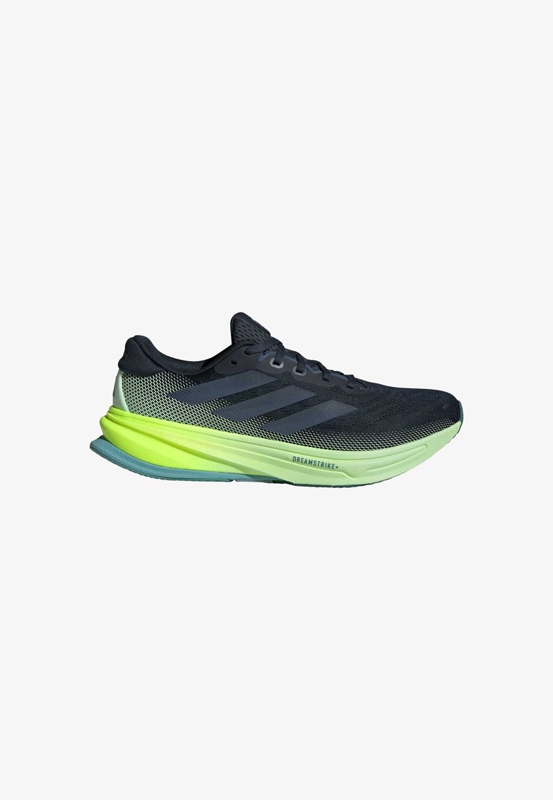 Chaussure de course Adidas noire et verte néon avec tige en mesh, trois bandes noires et semelle épaisse et rembourrée avec l'inscription « DREAMSTRIKE+ ».