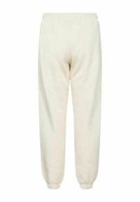 Vita, tapered joggers med elastisk midja och ankelfållar. Tillverkade av mjukt, strukturerat tyg; inga fickor eller tydliga mönster synliga.