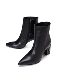 Czarne skórzane botki za kostkę z ostrymi noskami, zamkiem błyskawicznym po boku i kwadratowym obcasem z prostokątnym detalem.