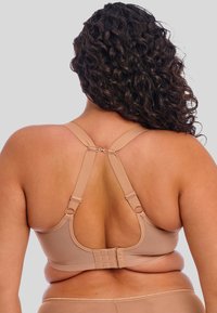 Beige beha met brede bandjes, haak-en-oogsluiting en een soepele, rekbare stof. Racerback-ontwerp met zichtbare ondersteuningshardware.