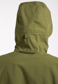 Voděodolná olivově zelená bunda s kapucí. Obsahuje nastavitelné stahovací šňůrky a hladký matný povrch. Jednoduchý design bez viditelných log.