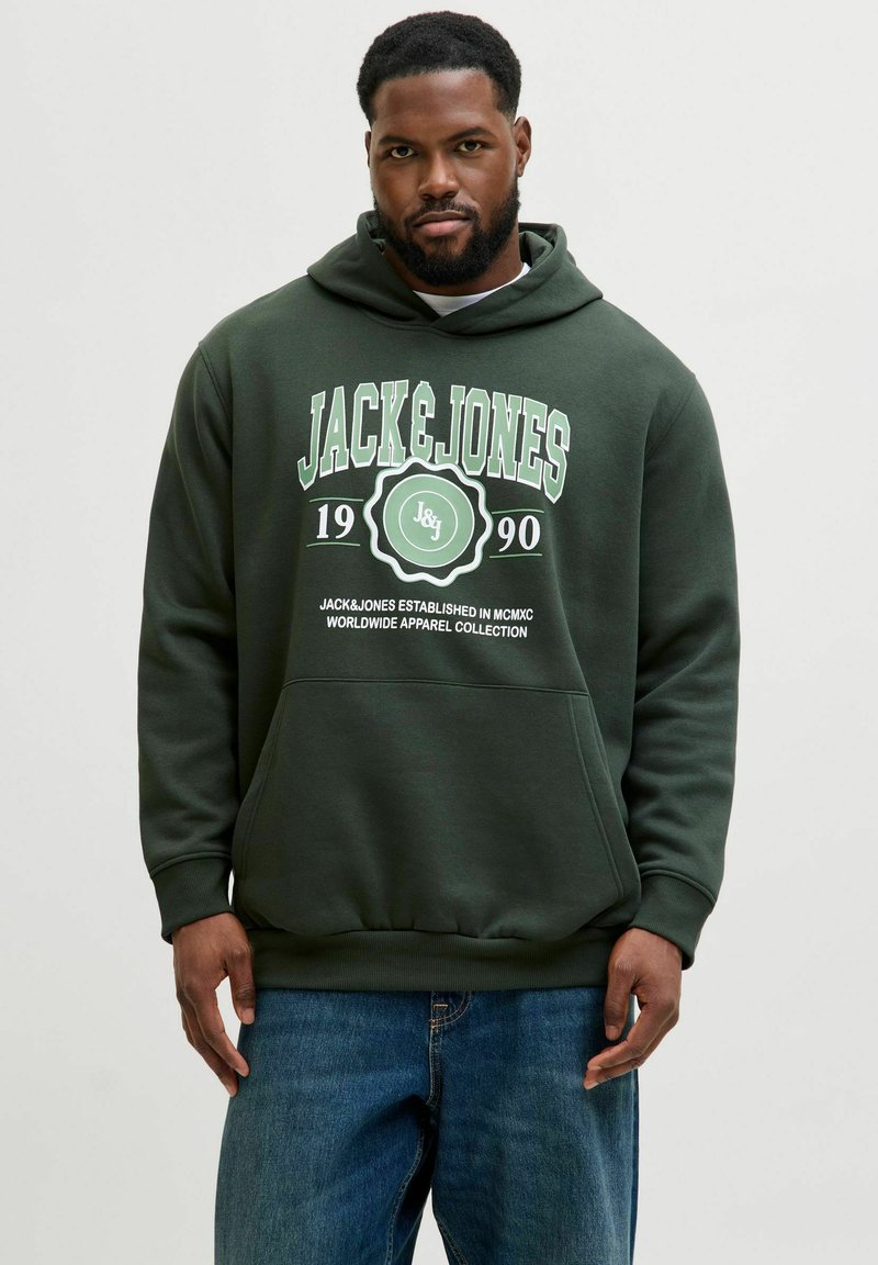 Sudadera de color verde oscuro con un gráfico frontal que presenta "JACK&JONES 1990" en blanco y verde. El material parece suave; incluye un bolsillo tipo canguro.