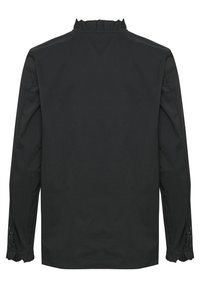 Melnā garā piedurkņu krekls ar rīvētu apkakli, pogājamiem manžetēm un gludu tekstūru. Aizmugures skats izceļ tā minimālistisko dizainu.