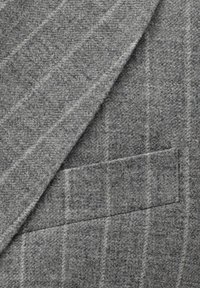 Grauer Wollblazer mit einer strukturierten Oberfläche, der dezente vertikale Streifen und eine aufgesetzte Tasche auf der linken Seite aufweist.