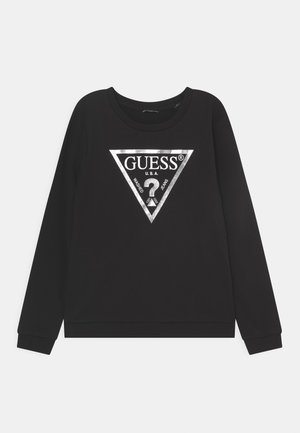 Sweat-shirt noir à manches longues avec logo triangulaire argenté GUESS et texte "U.S.A. Washed Jeans" centré sur le devant.