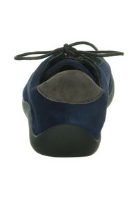 Marineblauwe suède sneaker met een donkergrijze hielpatch, zwarte zool en zwarte veters gestrikt in een strik, bekeken van achteren.