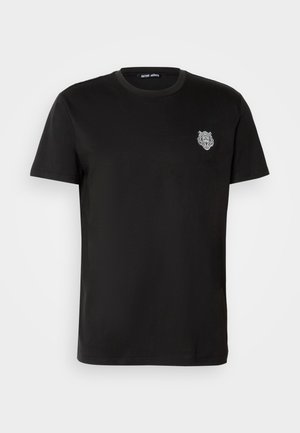 Camiseta negra de manga corta con un pequeño logo de cabeza de tigre blanco bordado en el lado izquierdo del pecho y cuello redondo.