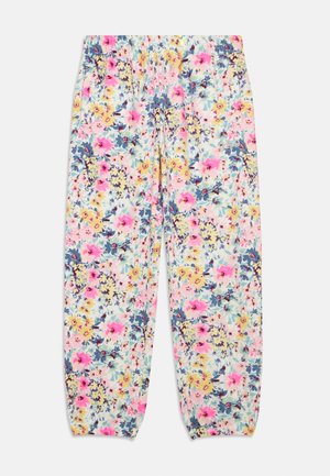 Løse bukser med elastisk linning og manchetter, med et flerfarvet blomsterprint med pink, gule og blå blomster på hvid baggrund.